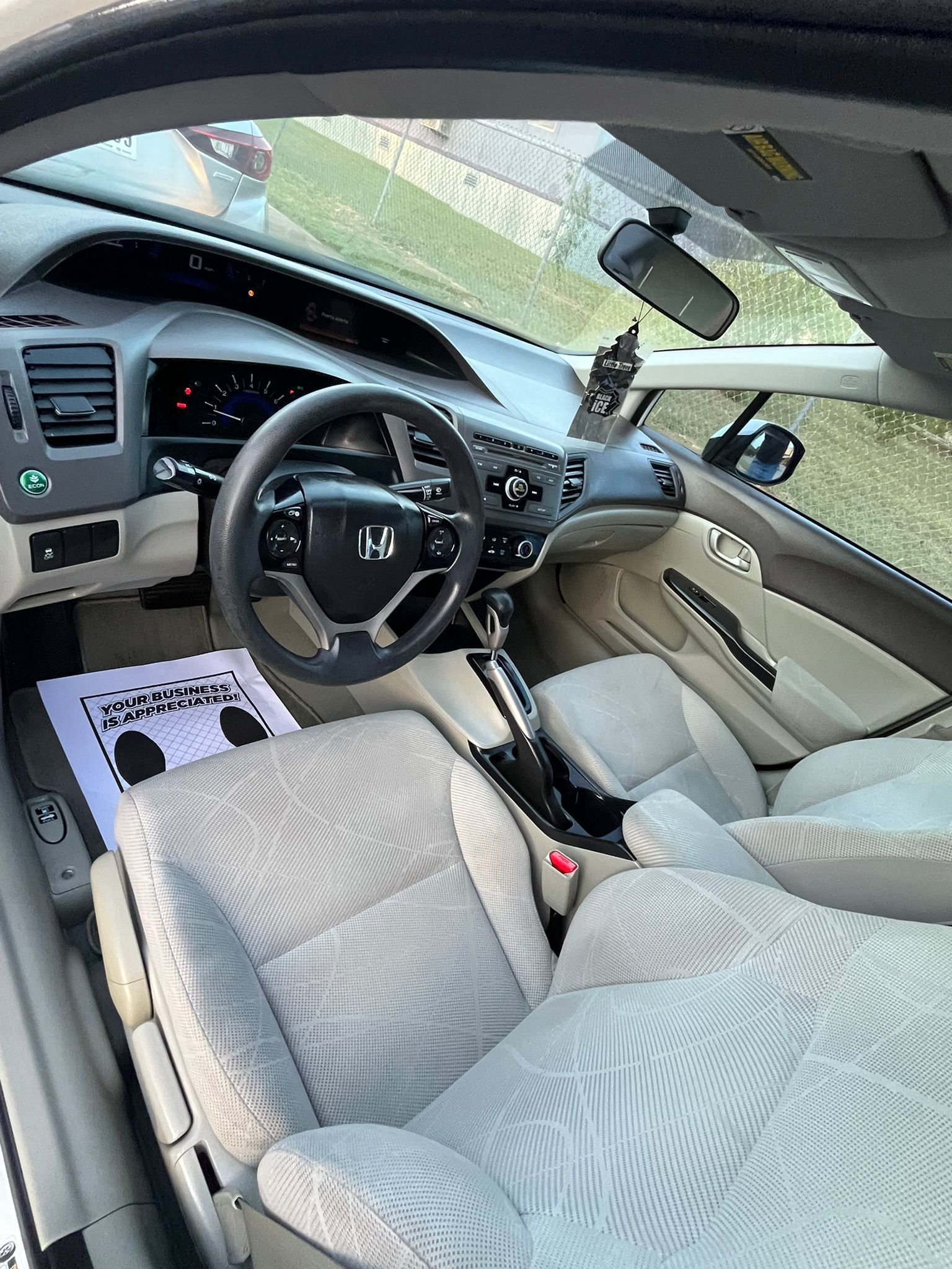 Honda car interior with beige patterned seats and steering wheel, viewed from the driver side