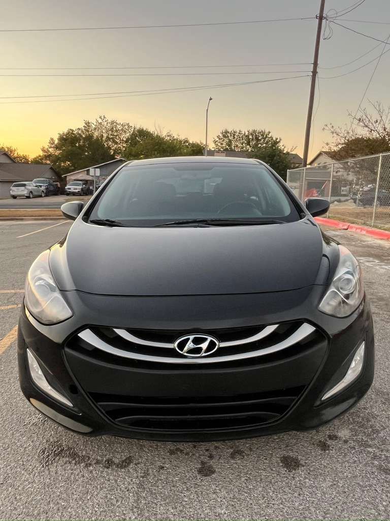 Front view of a black Hyundai sedan parked outdoors at sunset