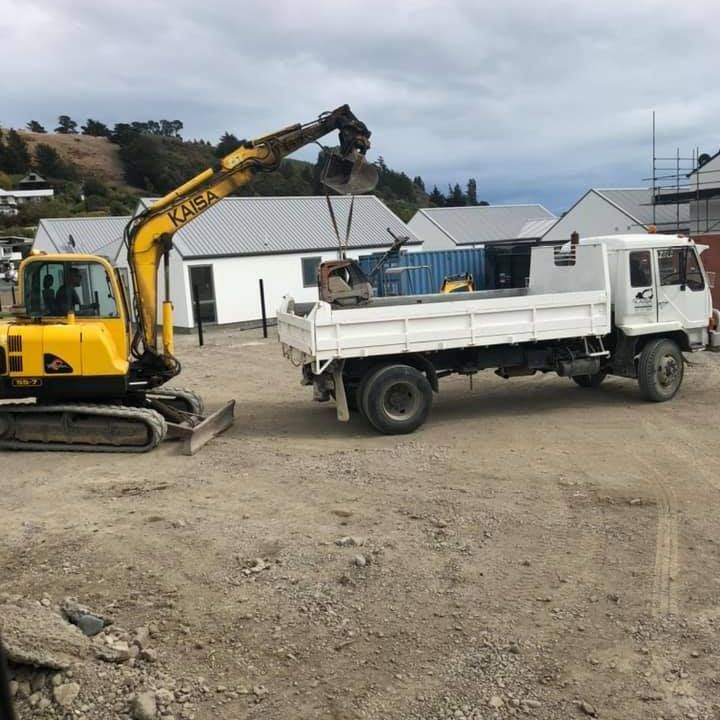 A yellow excavator is digging a hole in the dirt. A yellow excavator is digging a hole in the dirt.