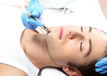 Clinician using a handheld device on a woman’s chin during a facial treatment