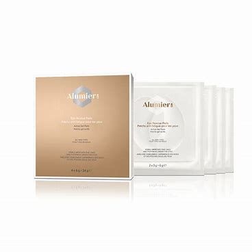 Gold and white facial mask packaging with stacked sachets on a white background