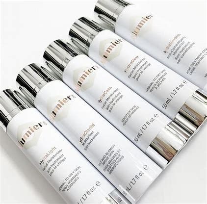 Five white cosmetic lotion tubes with silver caps arranged diagonally on a white background