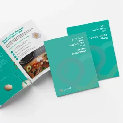 Turquoise food and drinks guidebook and booklet set laid out on a white background