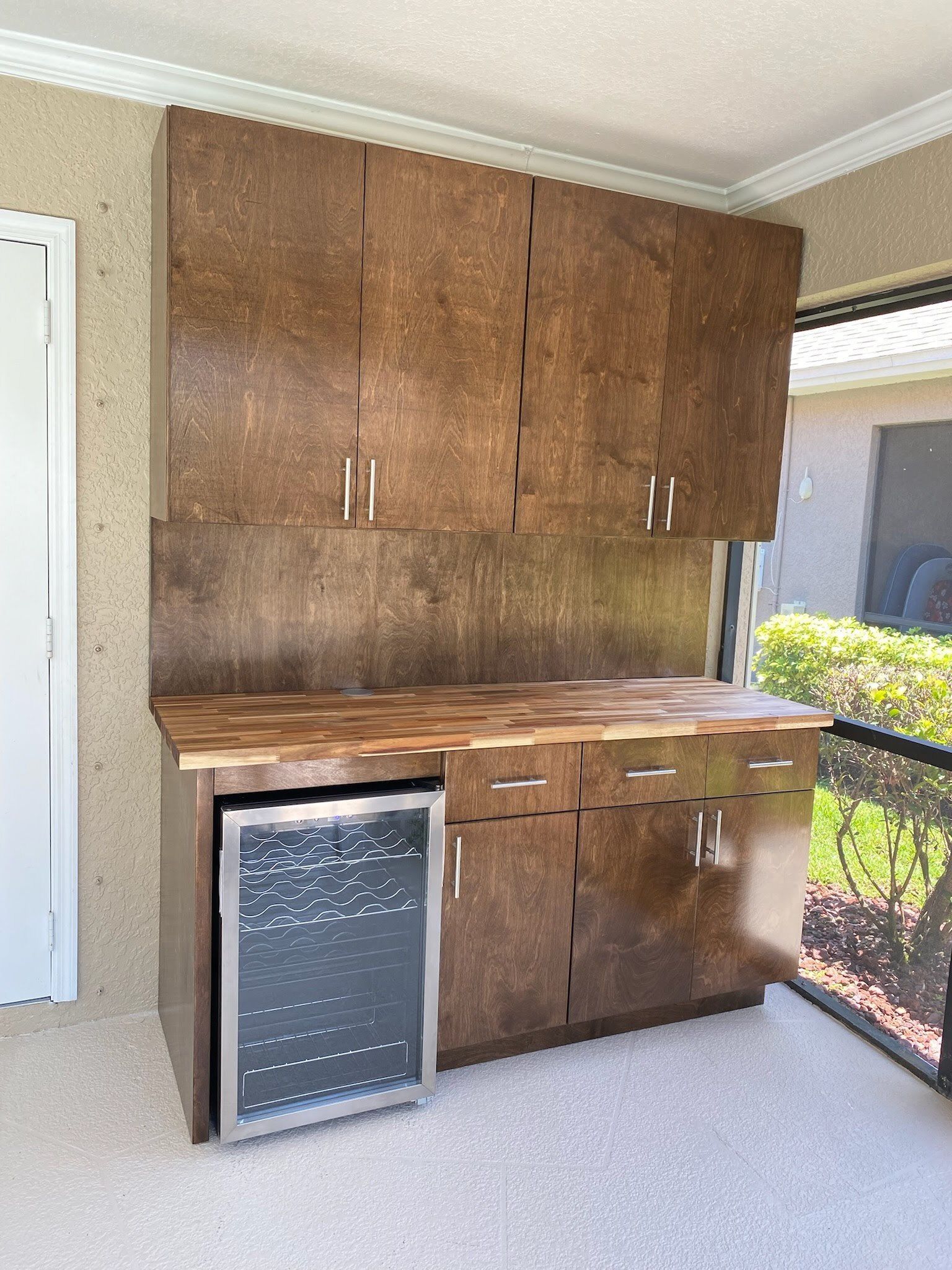 A kitchen with wooden cabinets and a wine refrigerator.
