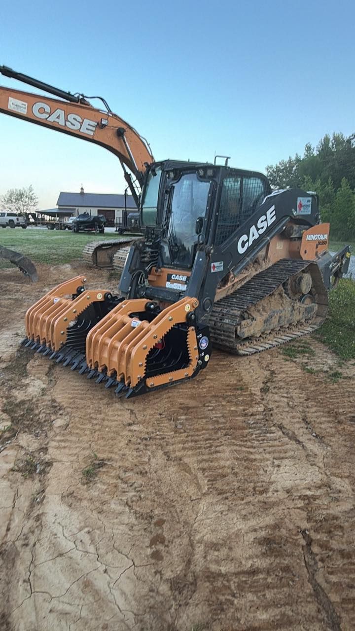 Orange CASE excavator on a muddy construction site, equipped with a front bucket attachment.
