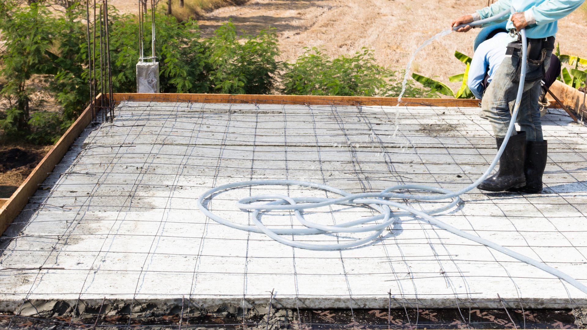 Oshawa concrete contractor spraying water on a concrete slab that is being built.
