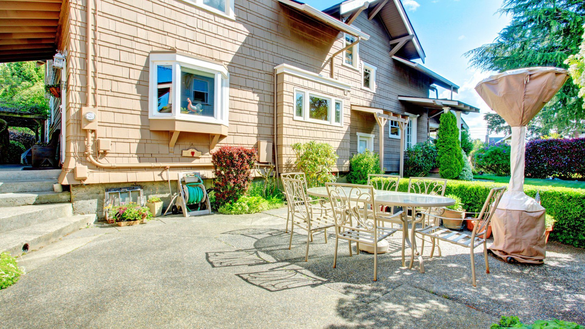 Circular stamped concrete patio in a backyard of a house. There are concrete steps leading down to the patio. Installed by Oshawa Custom Concrete.