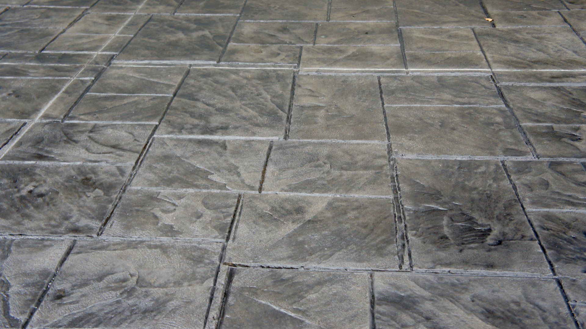 This is a picture of a stamped concrete patio in a backyard.  The concrete is a beige colour with a grey border.  The second picture is of a stamped concrete walkway.  The third picture is of a freshly poured concrete slab on grade.  The fourth picture is of textured and colored concrete.  The fifth picture is of a new concrete driveway.  The sixth picture is of a concrete pool deck.