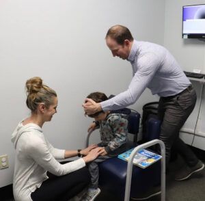 A man and a woman are playing with a child in a room.