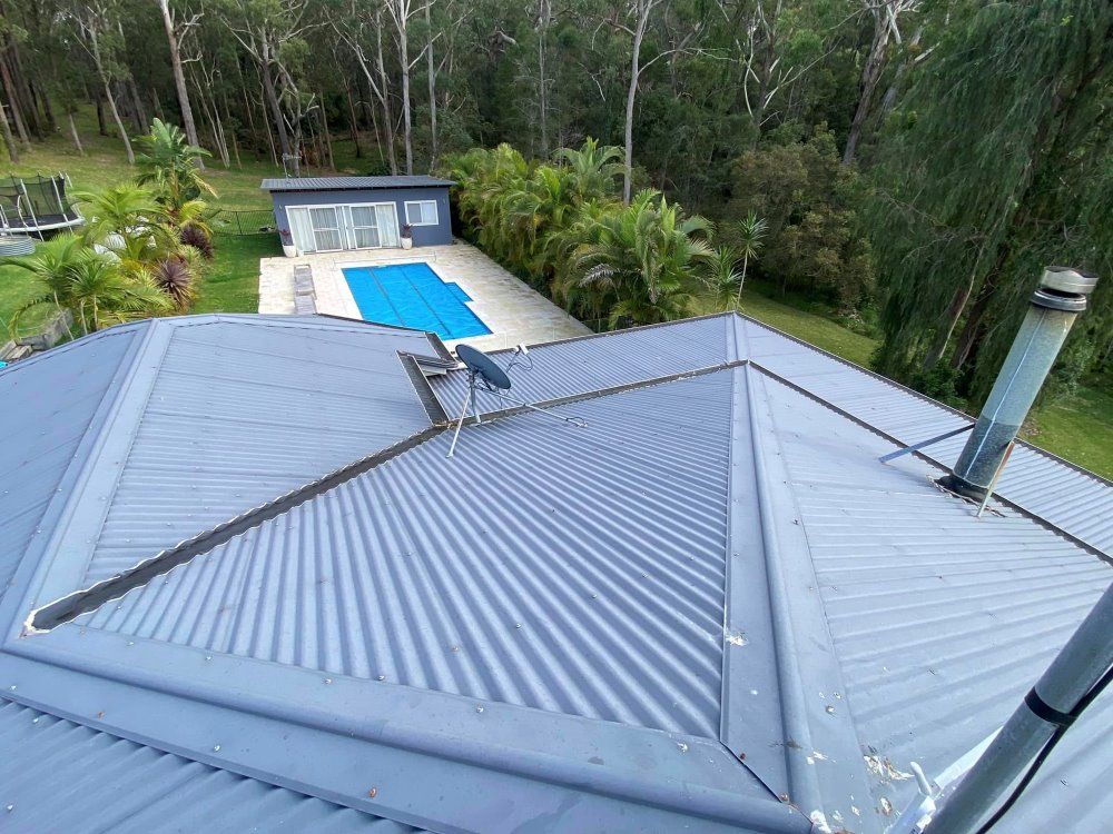 An Aerial View Of A Roof Of A House With A Pool In The Background — The Guttering Cleaning Man in Nabiac, NSW