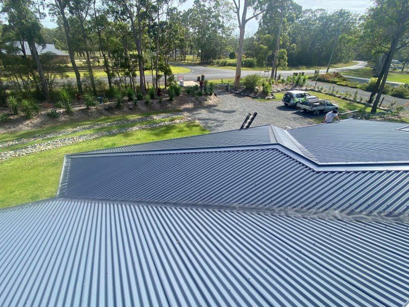 An Aerial View Of A Roof Of A House With Trees In The Background — The Guttering Cleaning Man in Pacific Palms, NSW