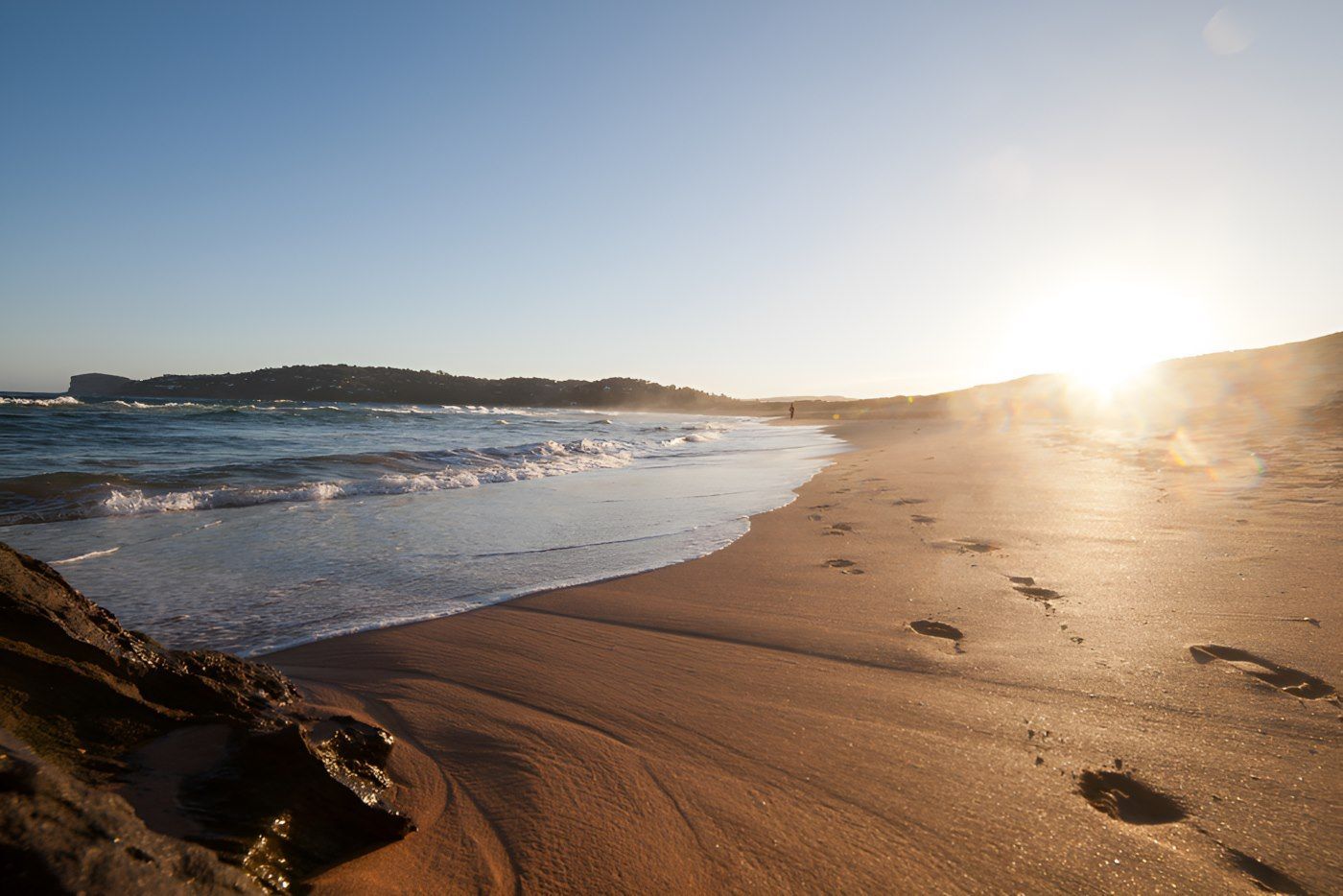 There Are Footprints In The Sand On The Beach At Sunset — The Guttering Cleaning Man in Pacific Palms, NSW