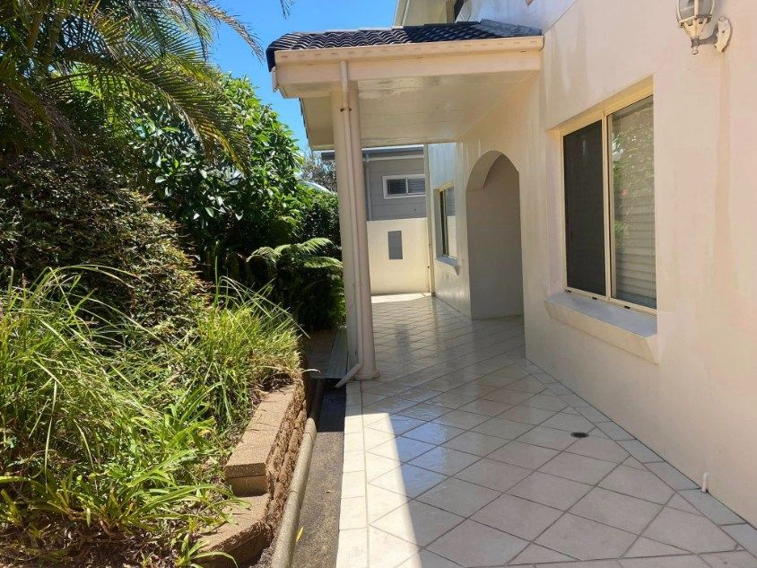 A Brick Walkway With A White Wall Behind It — The Guttering Cleaning Man in Forster, NSW