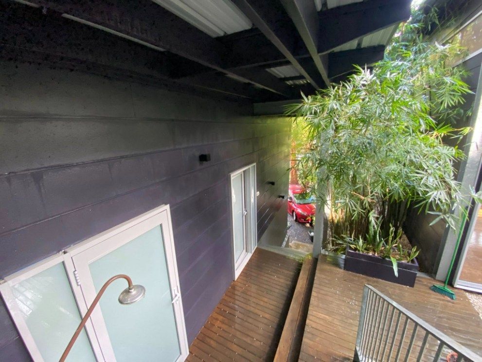 An Aerial View Of A House With A Wooden Deck And Stairs Leading To It — The Guttering Cleaning Man in Forster, NSW