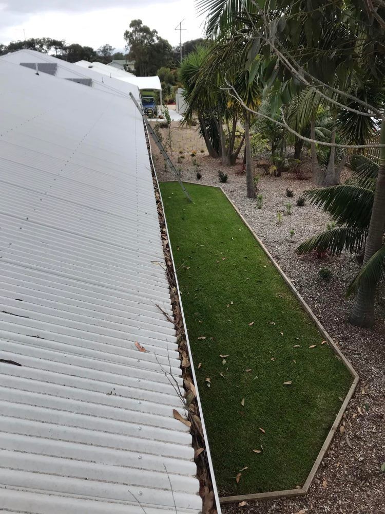 An Aerial View Of A White Roof And A Lush Green Lawn — The Guttering Cleaning Man in Wingham, NSW