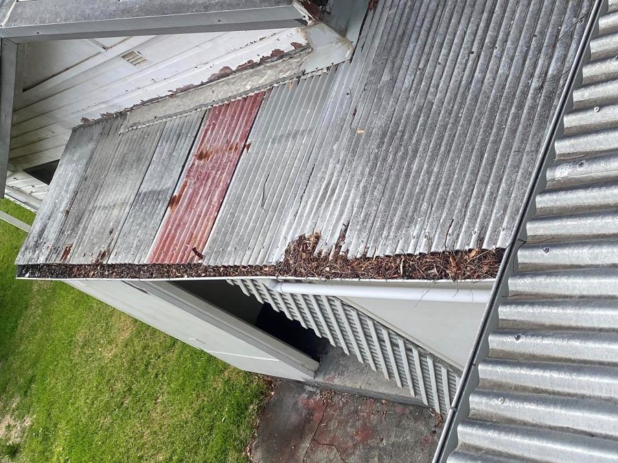 A roof with a gutter on it is sitting on top of a building.