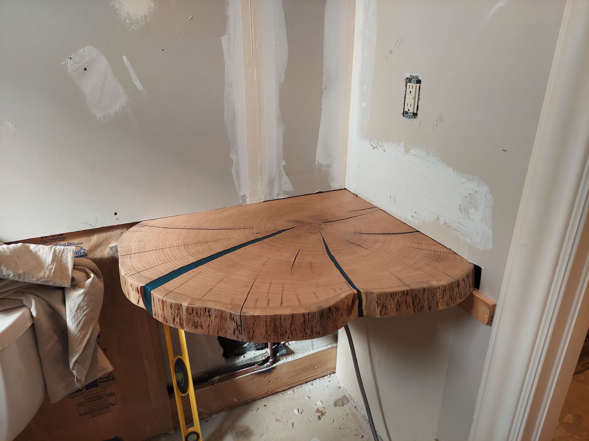 Partially built wooden corner countertop in a room under renovation