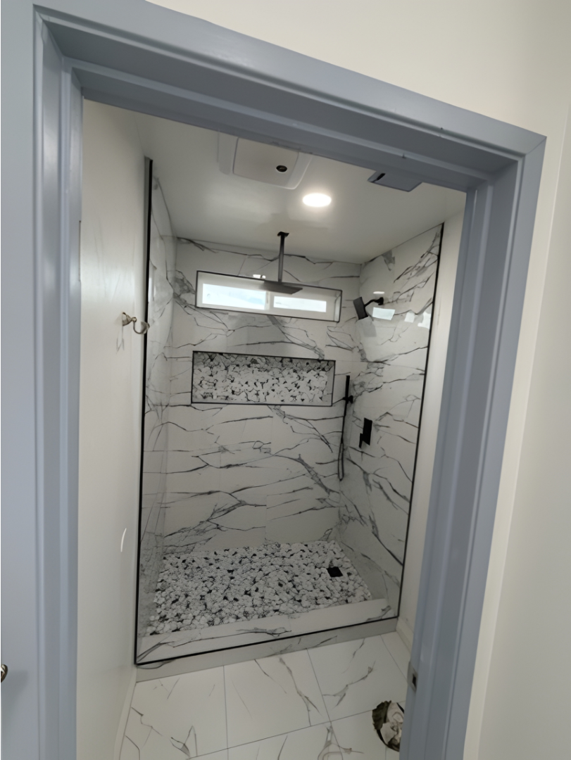 Modern bathroom with a double vanity, large shower, and soaking tub. Light wood cabinets, stone tile.