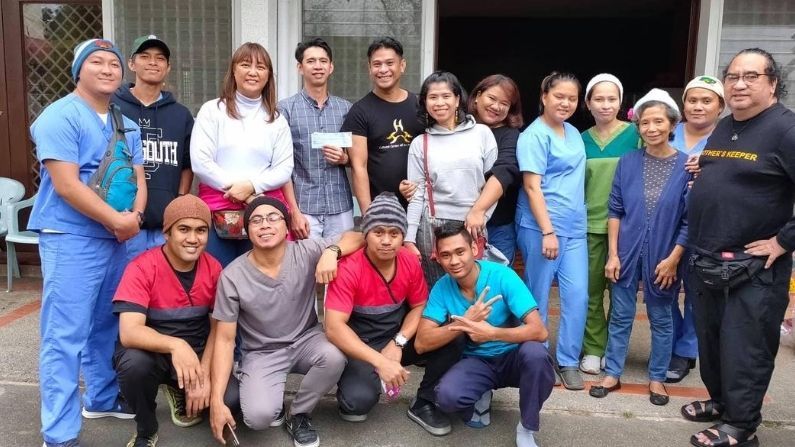 A group of people posing for a picture in front of a building.