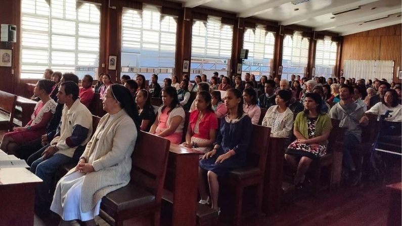 A large group of people are sitting in a church.