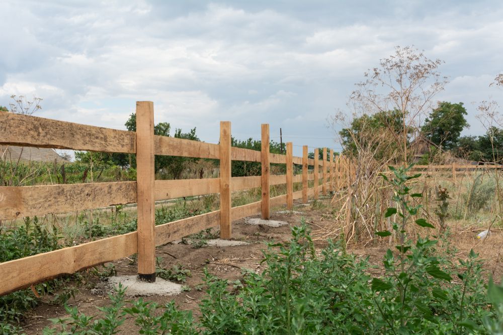A Wooden Fence is Being Built in a Field — Perry's Timber & Fencing In Shellharbour, NSW