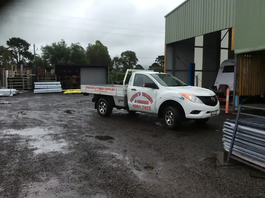 A White Truck Is Parked In Front Of A Building — Perry's Timber & Fencing In Dapto, NSW