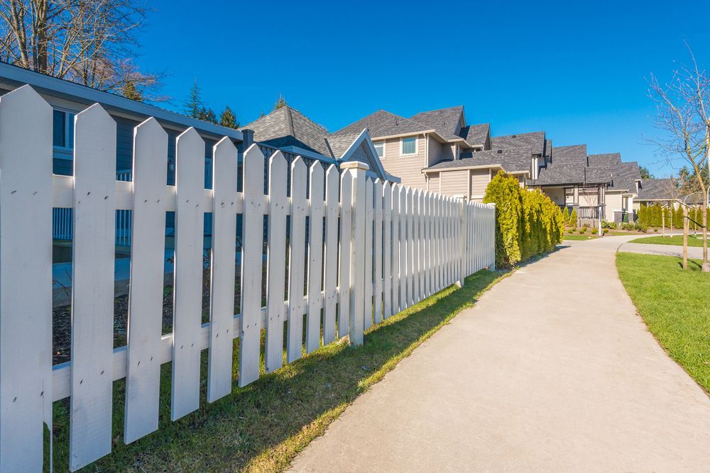 A White Picket Fence Along a Path in a Residential Area — Perry's Timber & Fencing In Albion Park, NSW