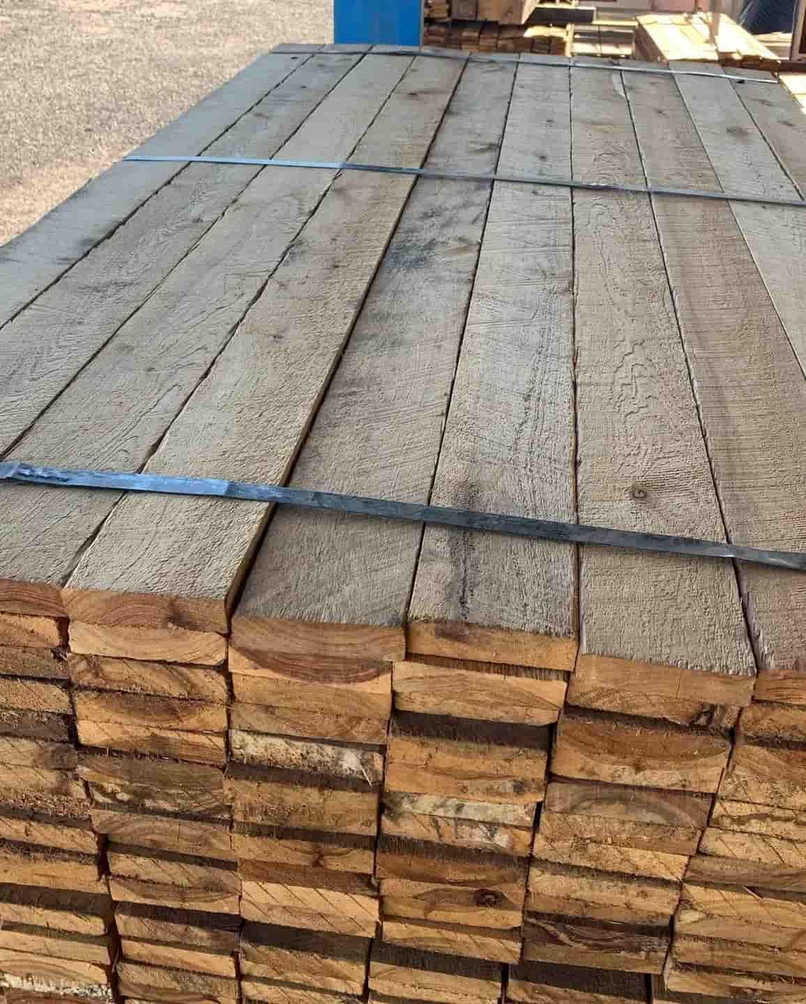 A Stack Of Wooden Boards Sitting On Top Of Each Other — Perry's Timber & Fencing In Dapto, NSW