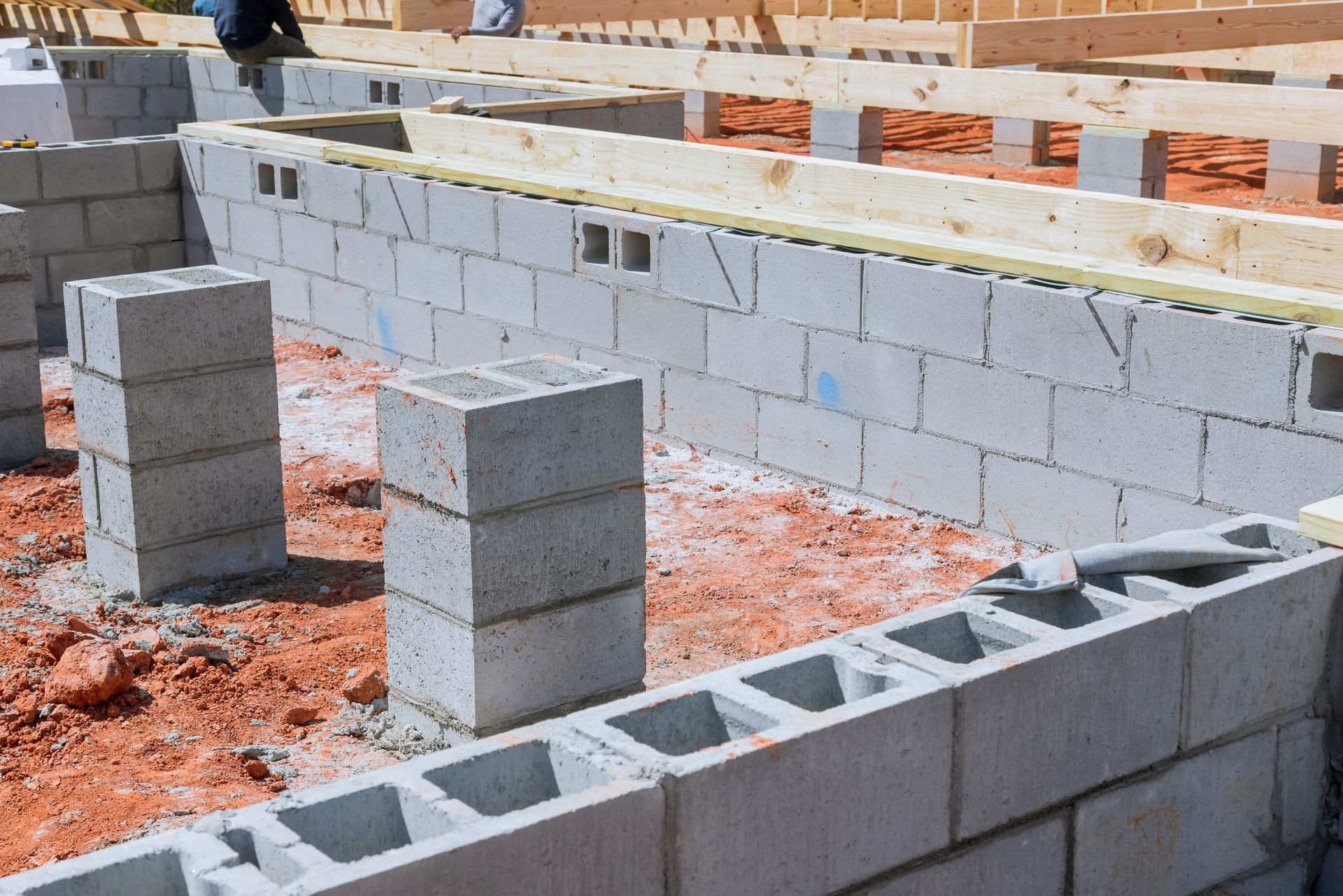 Foundation of a building under construction with concrete blocks and wooden beams.