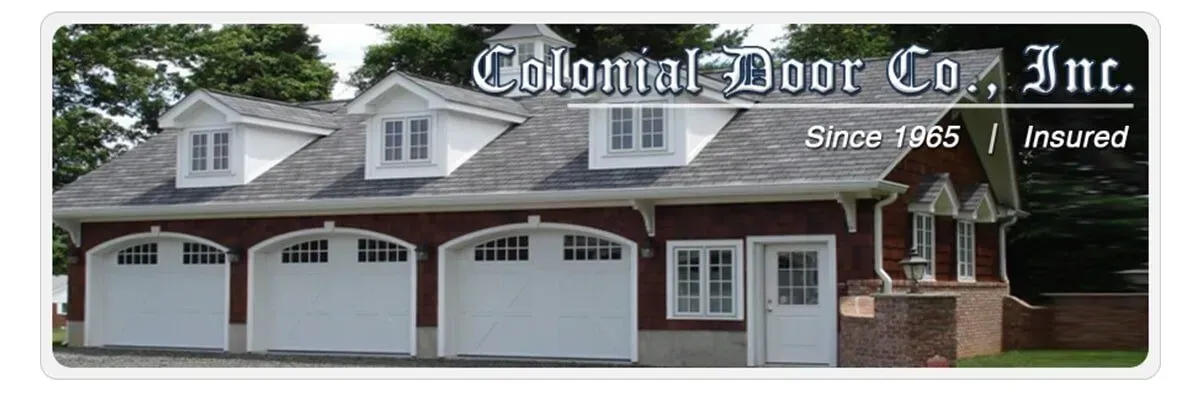 Exterior of Colonial Door Co. Inc. showroom with garage doors and trucks in front