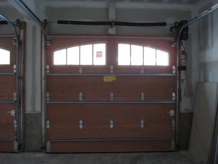Closed brown garage door with small window panes in a residential garage.