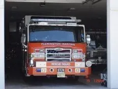 Red fire truck parked inside a garage, facing forward in a dark bay.