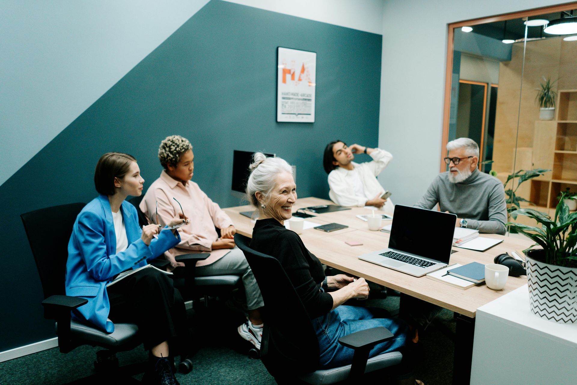 A group of people are sitting around a table in a conference room.