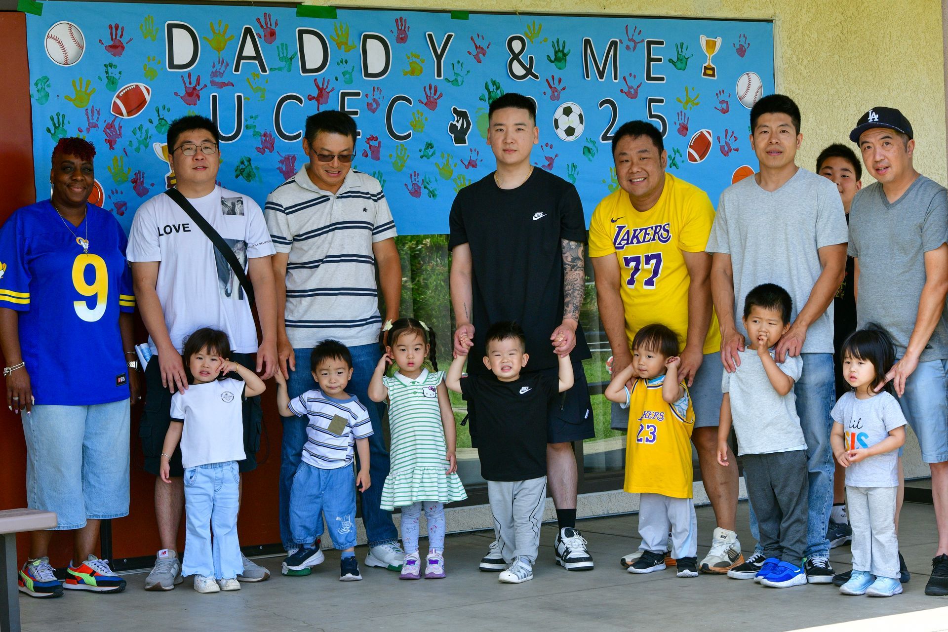 Group of fathers and children pose in front of a 