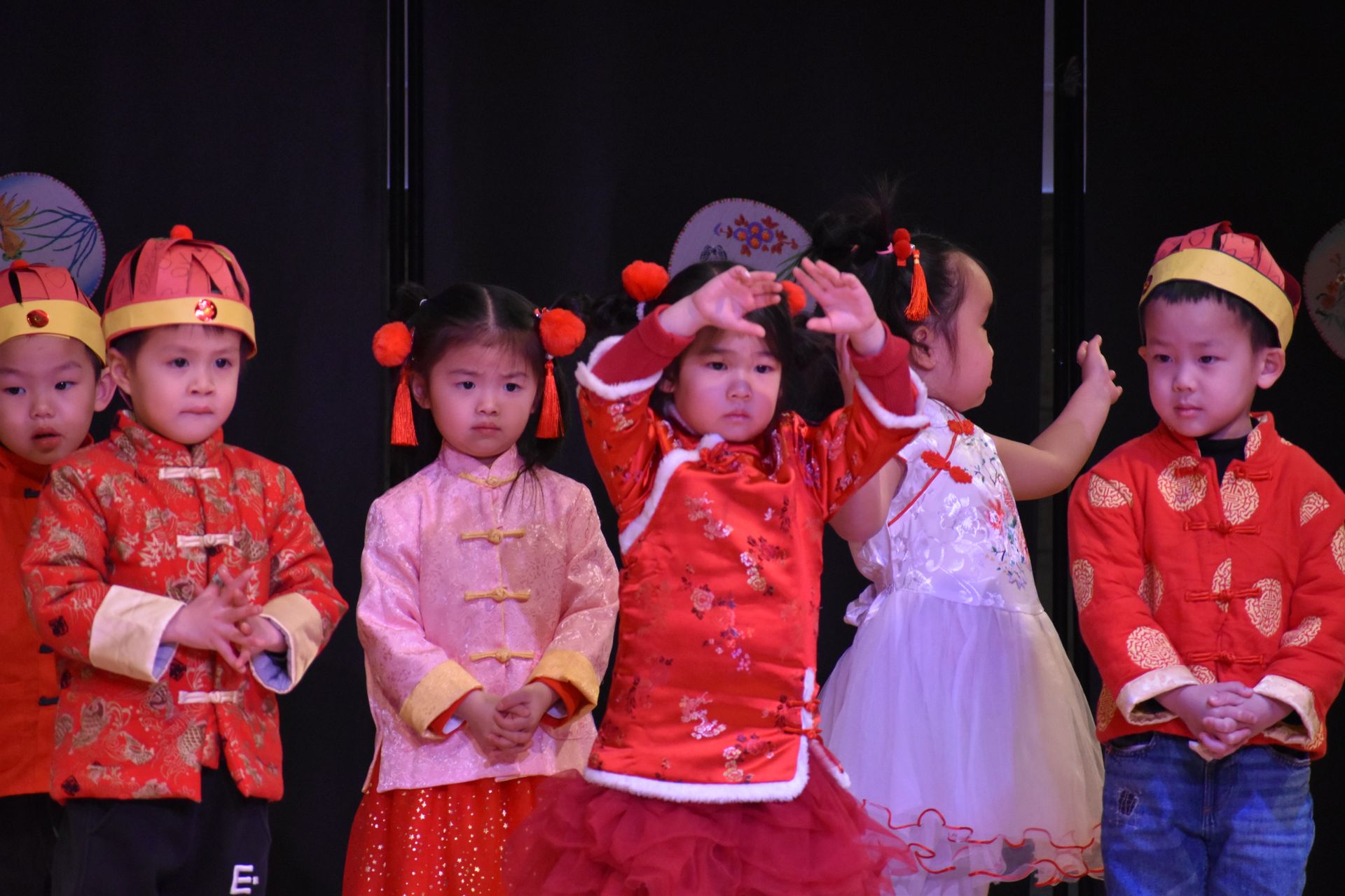 Children in red outfits performing on stage.
