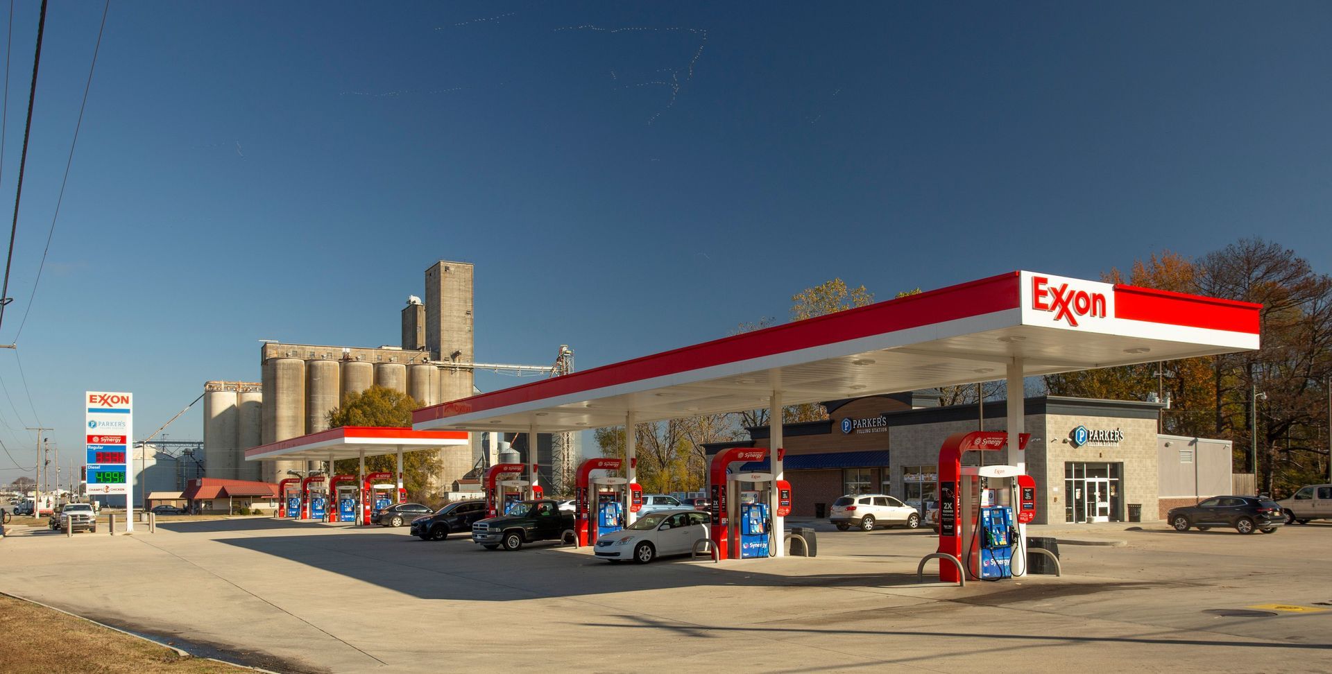An exxon gas station with cars parked in front of it