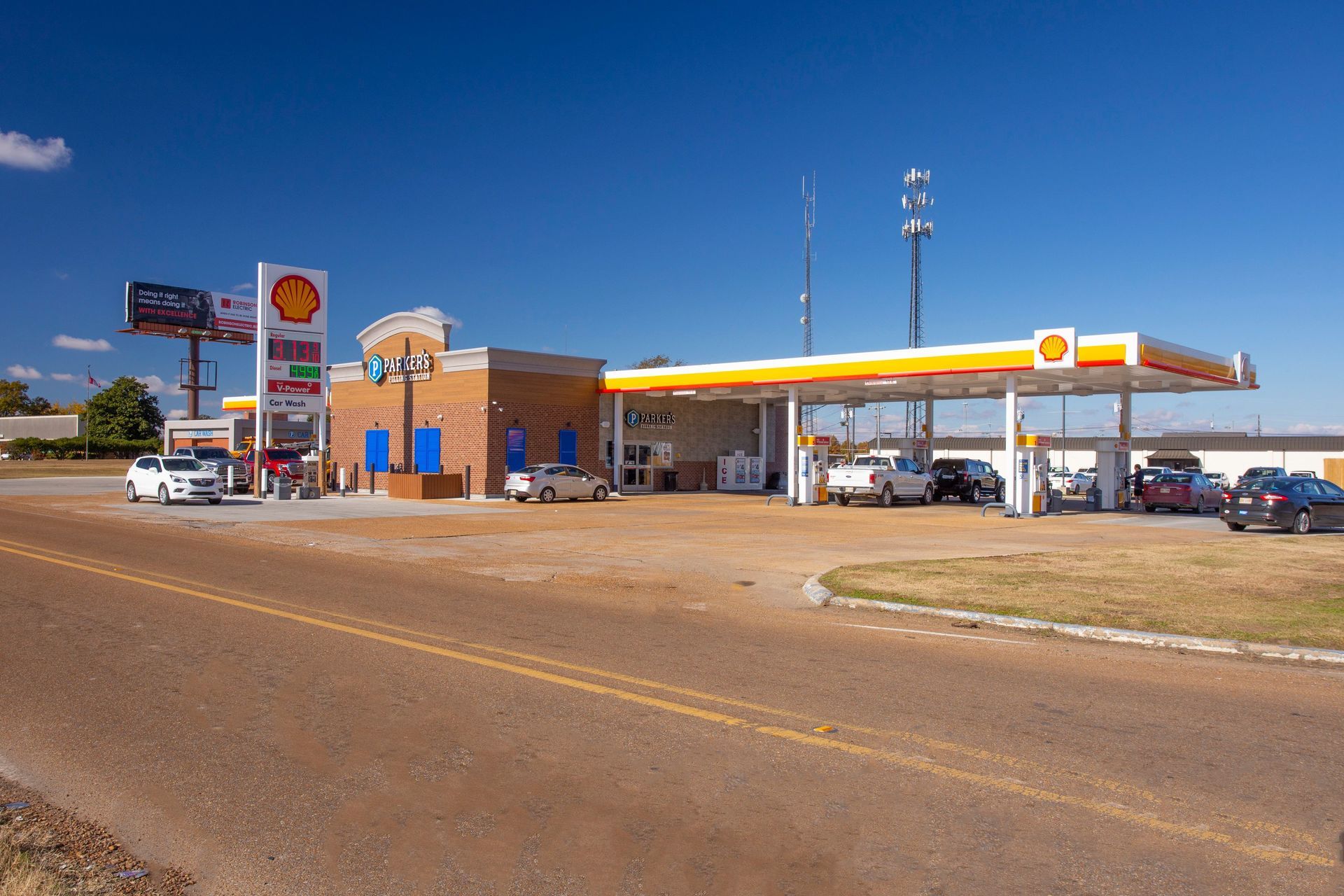 A gas station with cars parked in front of it