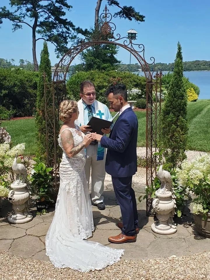 A bride and groom are getting married in front of a lake.