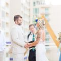 A bride and groom are holding hands during their wedding ceremony.