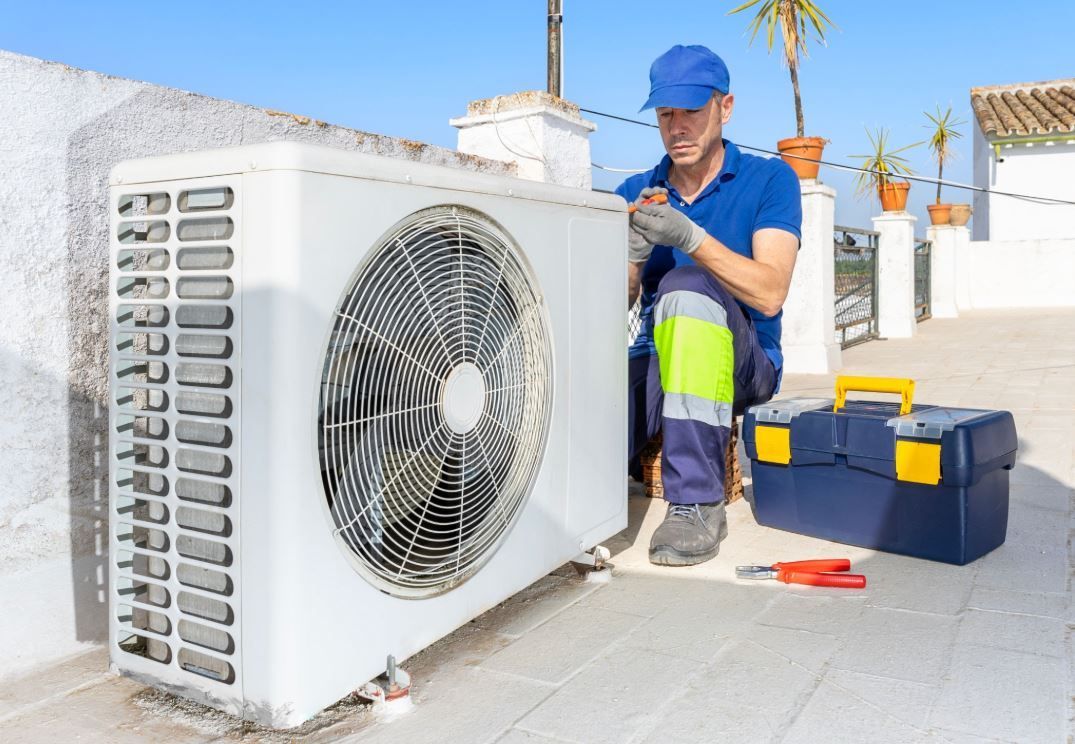 Professional HVAC service technician performing air conditioner maintenance