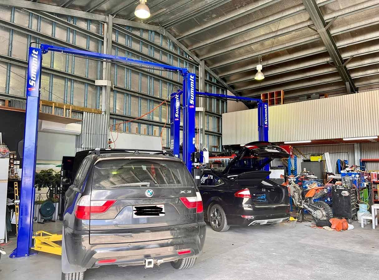 A Car is Sitting on a Lift in a Garage — Cairns Auto Electrical Mechanical Air & Audio in Mareeba, QLD