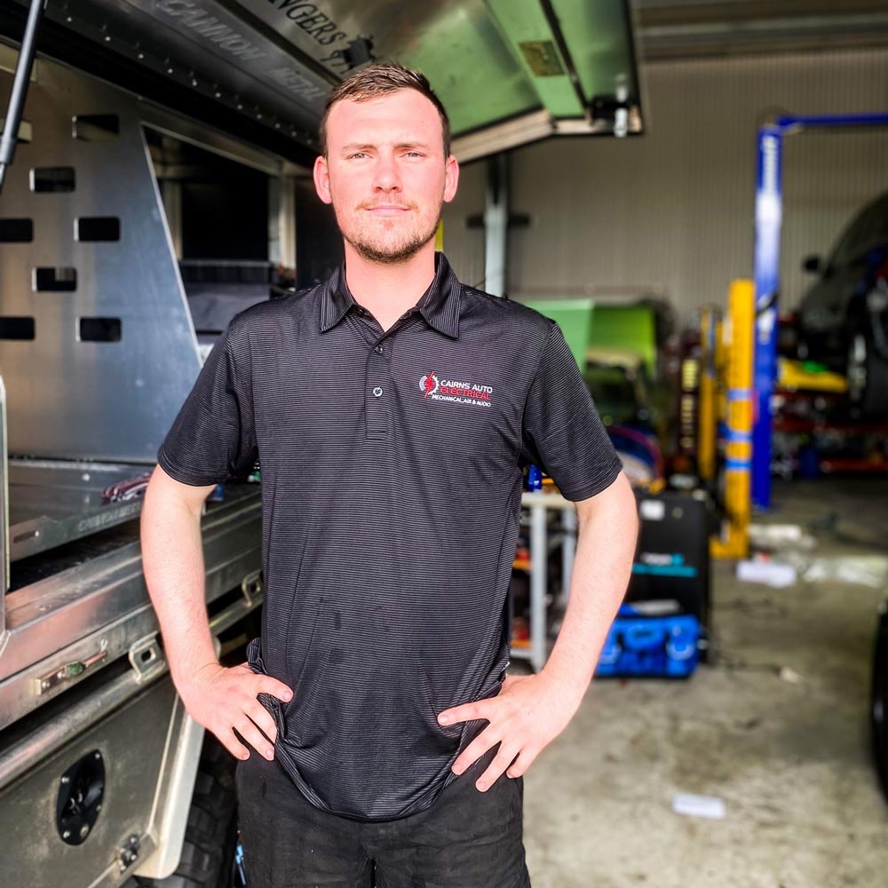 A Man is Standing in Front of a Truck — Cairns Auto Electrical Mechanical Air & Audio in Mission Beach, QLD