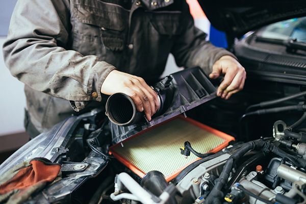 A Man is Working on the Engine of a Car — Cairns Auto Electrical Mechanical Air & Audio in Mareeba, QLD