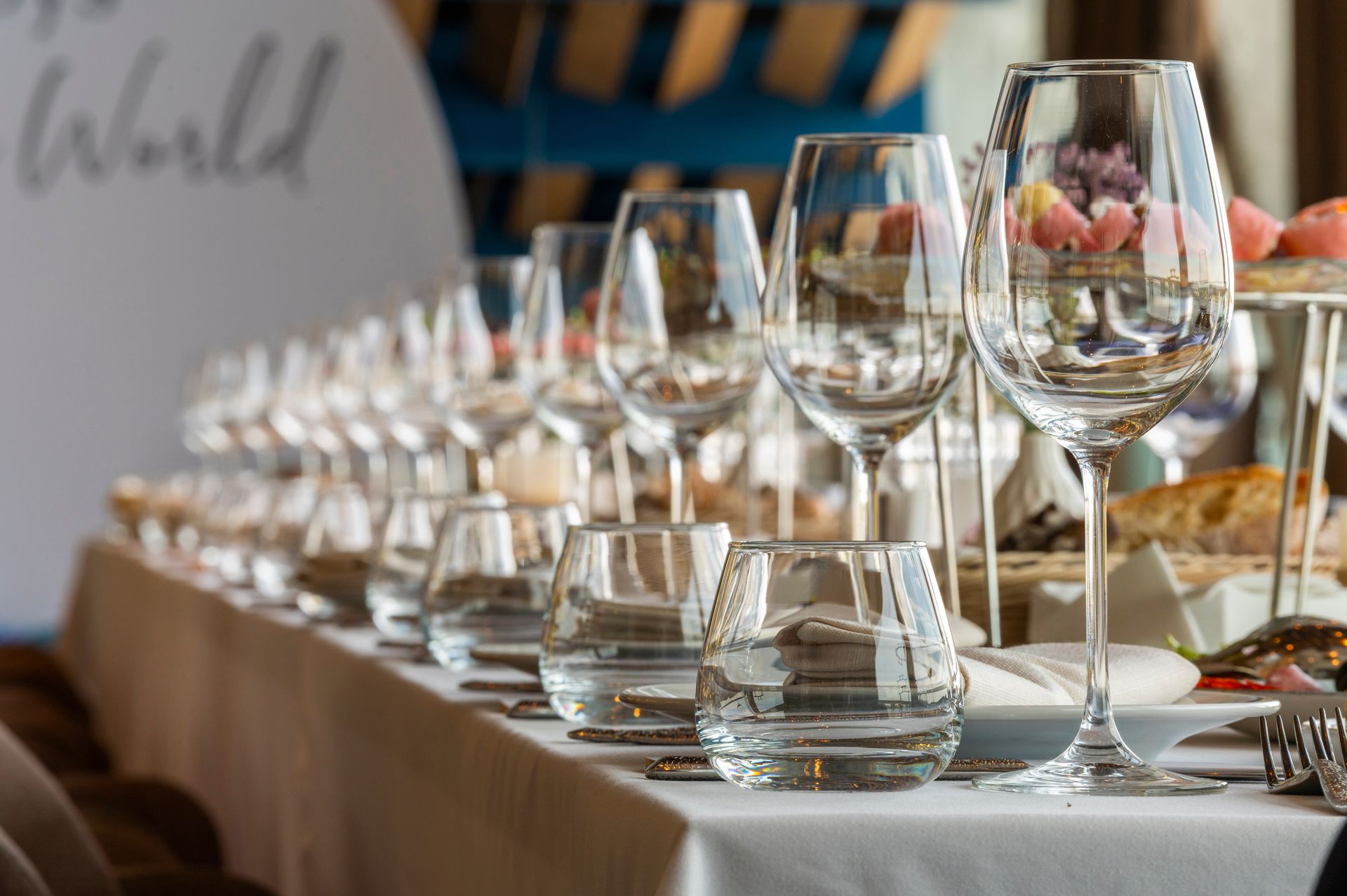 Elegant banquet table set with wine glasses, water glasses, and plates in a bright event venue