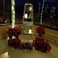 Decorated lantern display with white lights and red poinsettias in a festive indoor corner