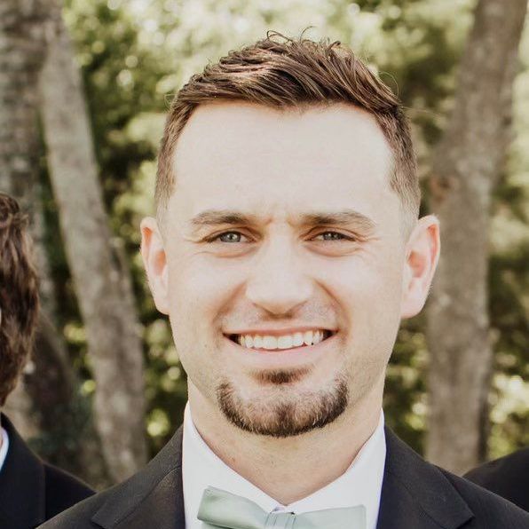 A man in a suit and bow tie is smiling for the camera