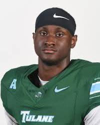 Tulane football player in green jersey and black headband, facing forward with neutral expression