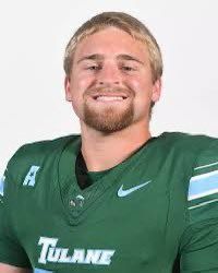 Portrait of a Tulane football player in a green jersey, smiling against a white background
