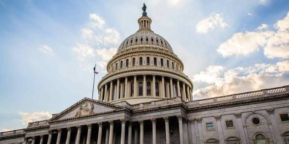 U.S. Capitol building dome and facade against a blue sky with clouds