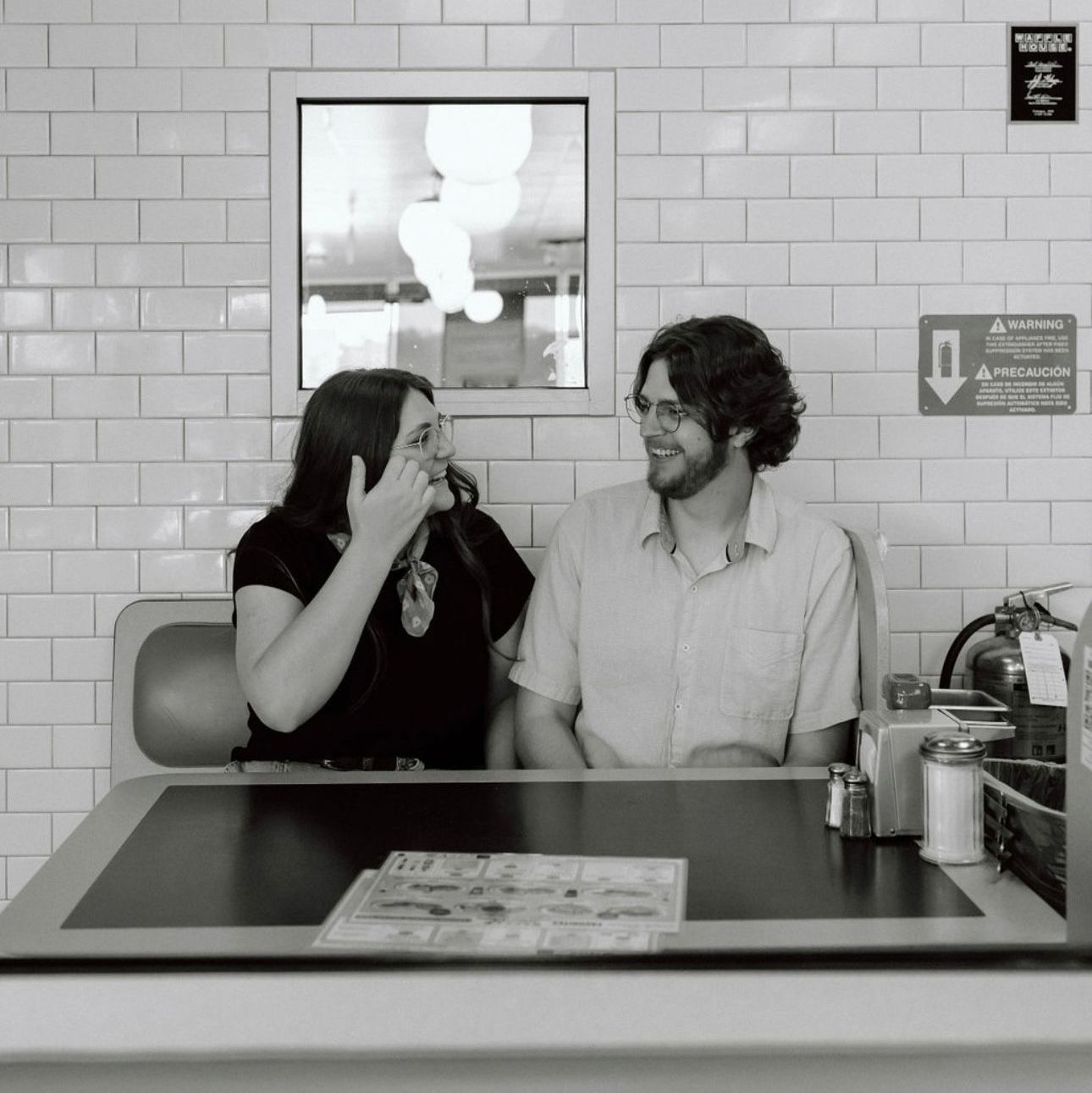 A black and white photo of a man and woman sitting at a counter